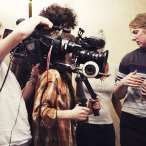Filming crew of three people shooting two women talking